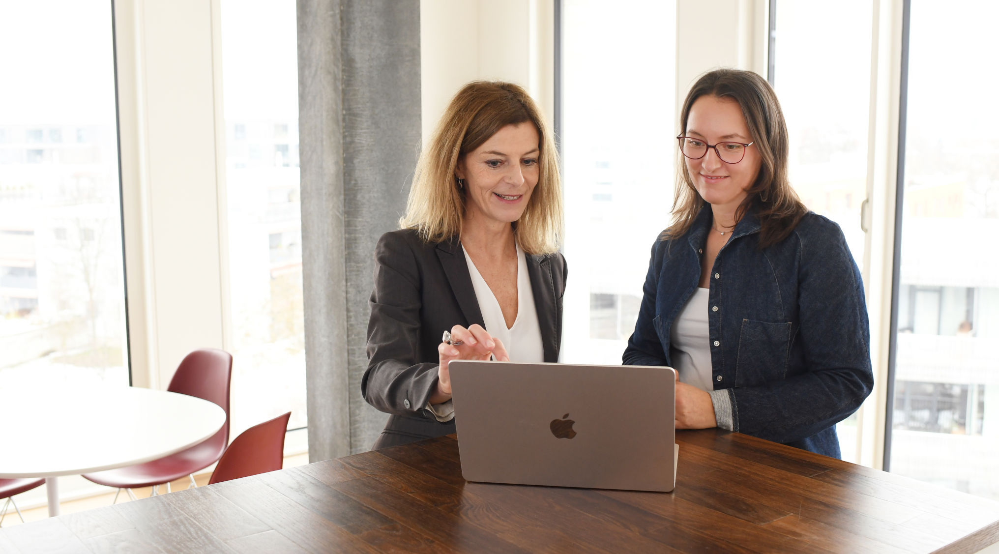 Manuela Langos und Sabine Zeilinger diskutieren stehend am Tisch
